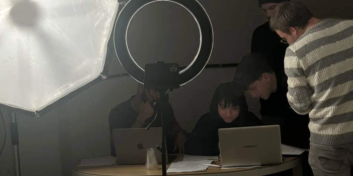 Studenti al lavoro dietro le luci e i computer del set